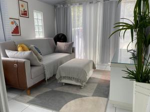 a living room with a couch and a plant at Anitápolis central -apartamento com jardim in Annitapolis