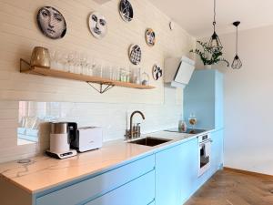 a kitchen with blue cabinets and a sink at Old Town Fabulous view apartment in Tallinn +31 photos