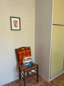 a pile of books sitting on a chair next to a refrigerator at Salt & Sun Terrace Seafront in Agioi Apostoli