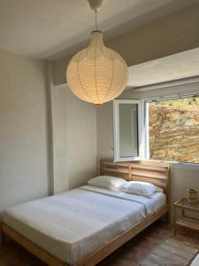 a bedroom with a bed with a chandelier above it at Salt & Sun Terrace Seafront in Agioi Apostoli