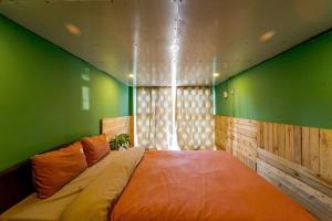 a bedroom with a large bed with green walls at Pine Aura Dalat Inn in Da Lat