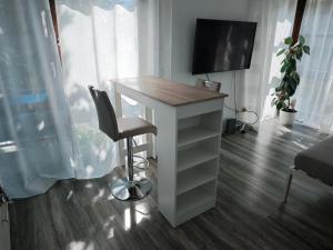 a desk with a television and a chair in a room at City Apartment, 27 qm, 2 Personen, high Sp WLAN in Paderborn