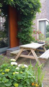 a wooden picnic table and bench in a garden at Eastendroom in Amsterdam