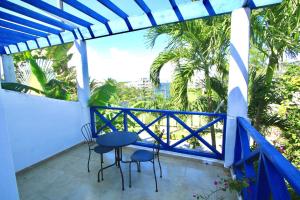 a balcony with chairs and a table and a view of the ocean at Bayahibe Essentials Rooms in Bayahibe