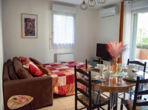 a living room with a couch and a table at L'Etoile Biterroise - Location appartement de vacances - Béziers in Béziers