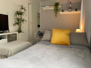 a bedroom with a bed and a yellow pillow at Anitápolis central -apartamento com jardim in Annitapolis
