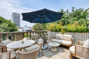 a patio with a table and chairs and an umbrella at Casa Talavera by Tasman in Mexico City