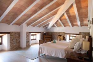 a bedroom with a large bed with a wooden ceiling at Barkala Mula in Artá +73 photos