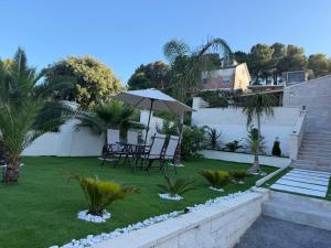 a patio with a table and an umbrella in a yard at Villa Mery Montserrat in Piera