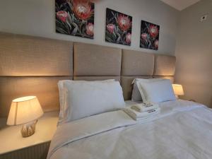 a bed in a bedroom with two pictures on the wall at Galani Homes Comfort 2-Bed Suite in Gaborone