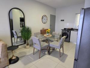 a dining room with a table and chairs and a clock at Galani Homes Comfort 2-Bed Suite in Gaborone