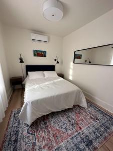 a bedroom with a white bed and a rug at Cozy Catskill Escape in Catskill