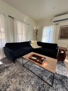 a living room with a black couch and a coffee table at Cozy Catskill Escape in Catskill
