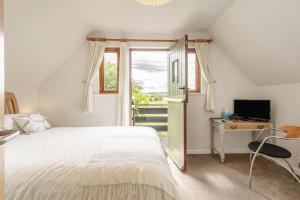 a bedroom with a bed and a desk and a window at 2 Bed in Woodbridge oc-owls in Ufford