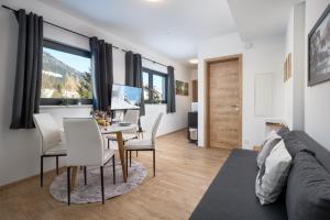 a living room with a couch and a table and chairs at Mountain Chalet Bergblick Top 2 in Fieberbrunn