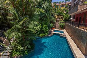 a swimming pool with a palm tree next to a building at Grand Hotel Guayaquil, Centro Histórico in Guayaquil