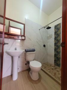 a bathroom with a toilet and a sink and a shower at Tayta Huasy in Montañita