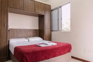 ein Schlafzimmer mit einem Bett, auf dem eine rote Decke liegt in der Unterkunft HANNA Amsterdam Apart Hotel & Eventos in Florianópolis