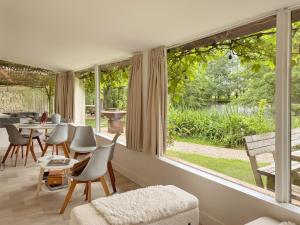 a living room with a large window looking out onto a garden at Charming chalet with Pond in Kortessem in Tongeren