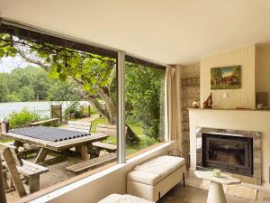 a screened in porch with a fireplace and a table at Charming chalet with Pond in Kortessem in Tongeren