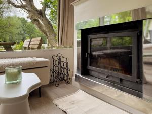 a living room with a fireplace with a window at Charming chalet with Pond in Kortessem in Tongeren