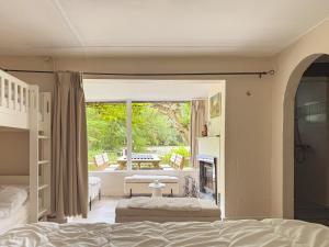 a bedroom with a bed and a living room with a fireplace at Charming chalet with Pond in Kortessem in Tongeren