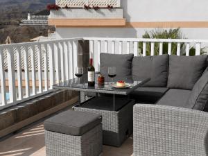 a patio with a couch and a table with wine glasses at AMADORES BEACH VIEW APARTMENT in Amadores