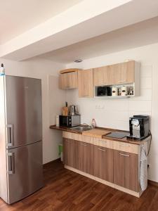 a kitchen with wooden cabinets and a stainless steel refrigerator at Apartmán Špičák in Špičák