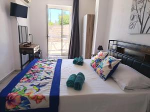 a bedroom with a bed with blue slippers on it at Villa Rosa in Surrau in Arzachena