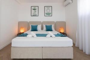 a bedroom with a large white bed with blue pillows at Villa Gaj 2 in Novalja +42 photos