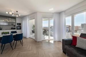 a living room with a couch and a table with chairs at Villa Gaj 2 in Novalja