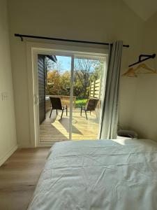 a bedroom with a bed and a sliding glass door at Modern cabin retreat in Catskill