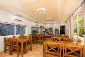 a dining room with wooden tables and chairs at Tam Coc Aurora Valley in Vũ Lâm