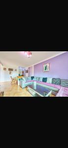 a living room with purple walls and couches at Residence oum kaltoum in Oued Laou