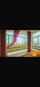 a room with windows with curtains and a table at Residence oum kaltoum in Oued Laou