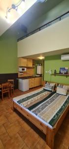 a large bed in a room with a kitchen at Maja Apartman in Gyula