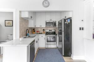 a kitchen with white cabinets and stainless steel appliances at Private Luxury Pool House Retreat in Lake Charles