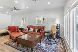 a living room with leather couches and a coffee table at Private Luxury Pool House Retreat in Lake Charles