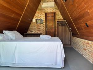 a large white bed in a room with a brick wall at Pousada Villa Al Mare in Luis Correia +16 photos