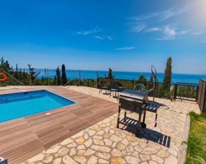 a patio with a pool and a grill and the ocean at Villa Vera in Agios Nikitas