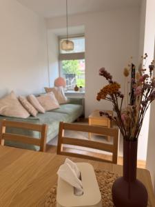 a living room with a vase with flowers on a table at Apartmán Mnichov in Vrbno pod Pradědem