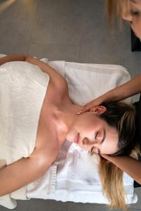 a woman laying on a bed in a towel at Hotel Ryo 74B Suites by Growing Group in Medellín