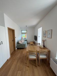 a living room with a table and a couch at Apartmán Mnichov in Vrbno pod Pradědem