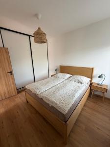 a bedroom with a bed with a wooden bed frame at Apartmán Mnichov in Vrbno pod Pradědem