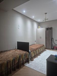 a room with two beds and a refrigerator at Jasmin Park in Baku