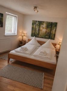 a bedroom with a bed with white sheets and pillows at Naturpanorama in Gleiszellen-Gleishorbach