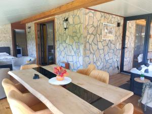 a dining room with a wooden table and a stone wall at Apartmani Nase brdo in Guča +27 photos