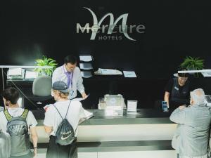 a group of people standing around a counter in a store at Mercure Santiago Centro in Santiago