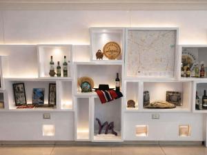 a white shelf with bottles and other items on it at Mercure Santiago Centro in Santiago