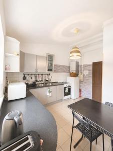 a kitchen with a table and a dining room at Konvoj szálló in Budapest
